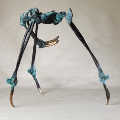 Fine art image of the sculpture Like a Fly by Karina K. Harper, standing in profile view. The lost wax cast bronze sculpture resembles a 3-legged spider with the leg bone anatomy of a human being. At the base of each leg is a polished bronze sharp claw. There are 2 bone arms that reach under the body of the spider. The spider's skin is a dark black bronze patina with crusty aqua knuckles.