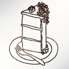 Modern, contemporary art: a wall-hanging polished metal sculpture in cast bronze filigree, the design features the abstract geometric lines and organic swirls of a decadent three-tired cake with rose petal frosting; inspired by the infamous quote by Marie Antoinette, "Let them eat cake!" and is displayed on a white background.