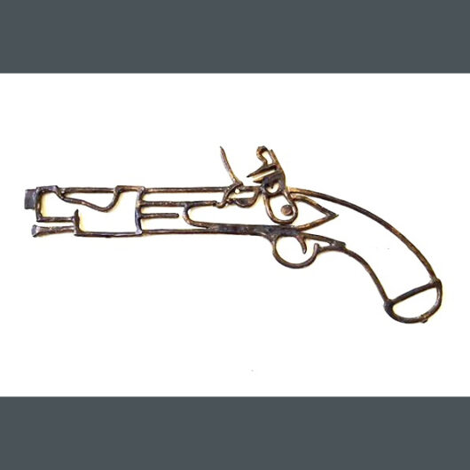 Modern, contemporary art: a wall-hanging oxidized metal sculpture in cast bronze filigree, the design features an abstract simplified line design of a French Flintlock pistol from 1774, a common firearm used in the days of the Reign of Terror during the French Revolution. It is displayed on a white background.